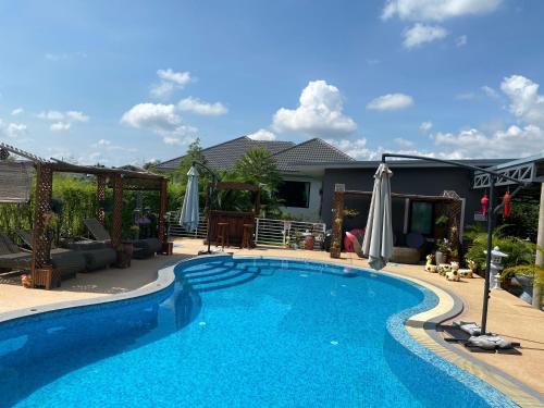 ein Schwimmbad in einem Hof neben einem Haus in der Unterkunft SB Holiday Resort Chiang Mai in Chiang Mai
