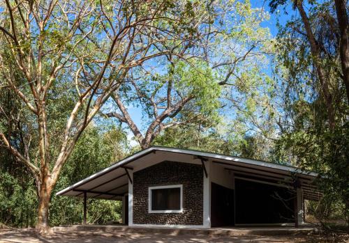 a small brick building with a window and a tree at Hacienda La Pacífica Eco-Lodge in Cañas