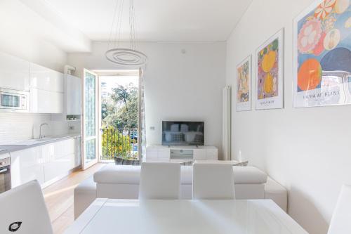 a white kitchen with a white table and chairs at Elena House Apartments in Viareggio