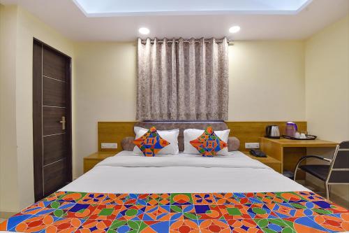 a bedroom with a bed with a colorful bedspread at FabHotel Pink City in Jaipur