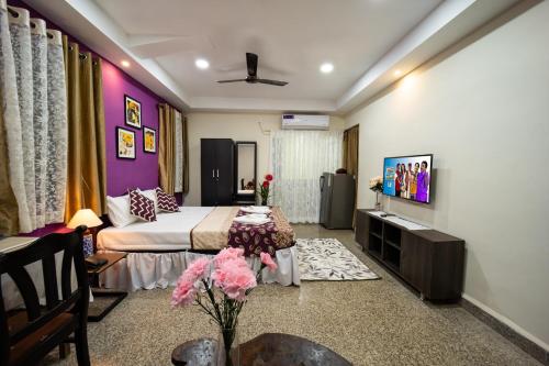 um quarto de hotel com uma cama e uma televisão em Celso's Home Stay em Panaji