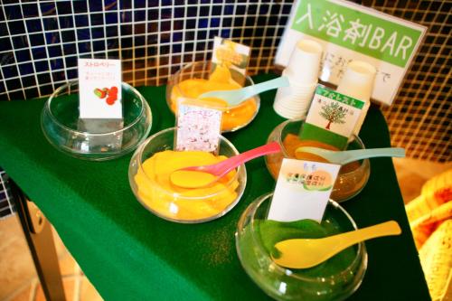 a green table with four bowls of orange juice at HOTEL CHECK INN BALI adult only in Tokyo