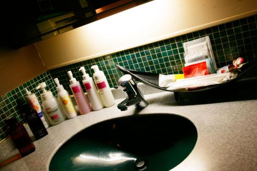 a bathroom sink with a black at HOTEL CHECK INN BALI adult only in Tokyo