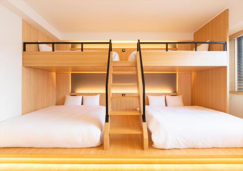two bunk beds in a room with white beds at fav Hida Takayama in Takayama
