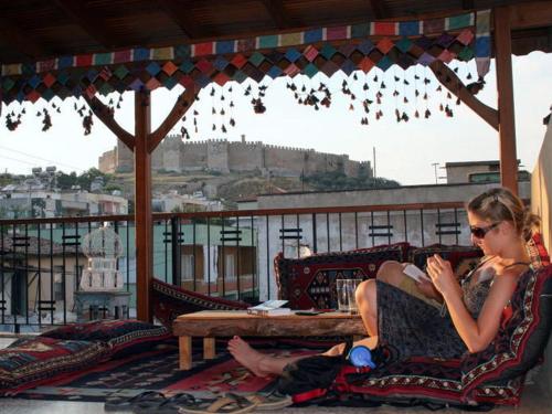 a woman sitting in chairs on a balcony at Tuncay Pension in Selcuk