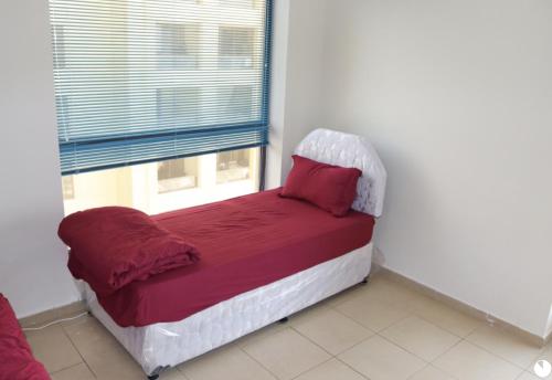 a white bed sitting in a bedroom next to a window at California Hostel Dubai Beach in Dubai