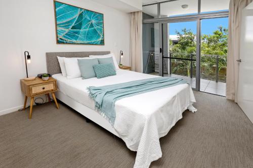 a bedroom with a large bed and a balcony at Pool View City Centre Apartment 206 in Cairns