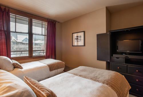 ein Hotelzimmer mit 2 Betten und einem Flachbild-TV in der Unterkunft Large Zephyr Mountain Lodge condo with fireplace and Village Views condo in Winter Park