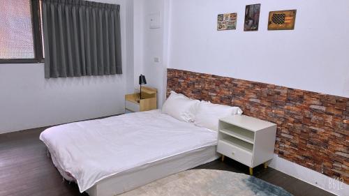 羅東鎮的住宿－Ck獨立房源公寓，一间卧室设有一张床和砖墙