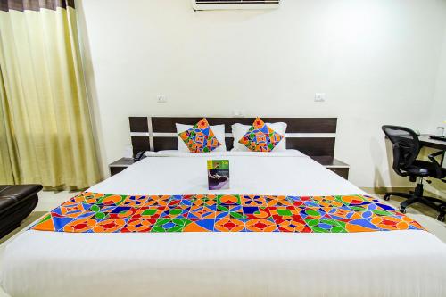 a bedroom with a bed with a colorful quilt on it at FabHotel Pride Inn in Hyderabad