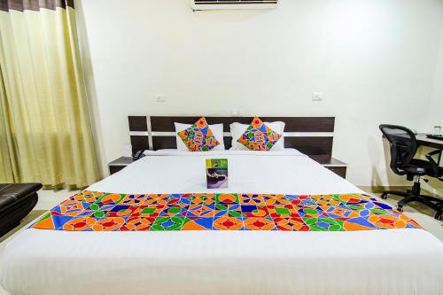 Un dormitorio con una cama con una colcha colorida. en FabHotel Pride Inn en Hyderabad