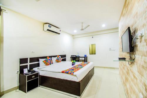a bedroom with a bed and a flat screen tv at FabHotel Pride Inn in Hyderabad