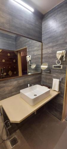 a bathroom with a sink and a mirror at Vikrama Heritage Resort Pavagadh in Hālol