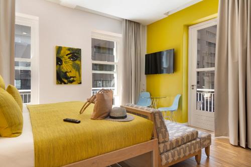Urban Oasis Aparthotel في كيب تاون: غرفة معيشة بجدران صفراء وأريكة