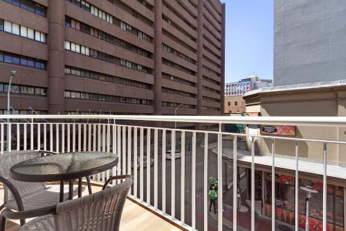 a balcony with a table and chairs and a building at Urban Oasis Aparthotel in Cape Town
