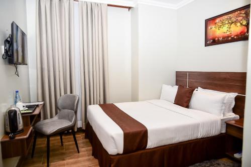 a hotel room with a bed and a chair at LA BEILA HOTEL MERU in Meru