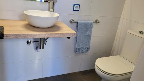 a bathroom with a bowl sink and a toilet at Acacies 25 in Torroella de Montgrí
