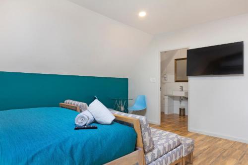 a bedroom with a blue bed and a couch at Urban Oasis Aparthotel in Cape Town