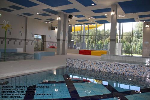 a pool in a building with a swimming pool at Hotel Olimpijski in Oświęcim