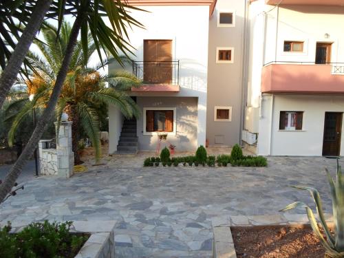 a house with a courtyard in front of a building at Arcadian Apartments & Studios in Xiropigado