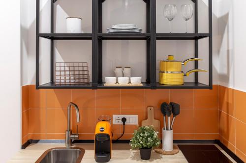 een keuken met een wastafel en een plank met borden bij Lovely nest in the city center Fast WiFi in Trieste