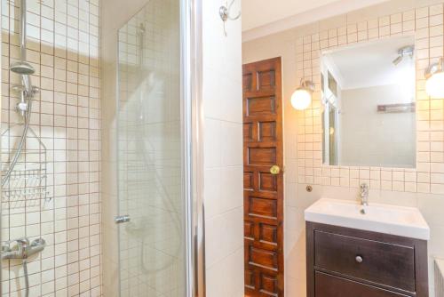 a bathroom with a shower and a sink and a mirror at Villa Jardin Tropical in Manilva
