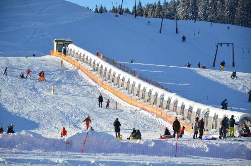 un grupo de personas esquiando por una pista cubierta de nieve en Tinyhouse Postalm en Abtenau