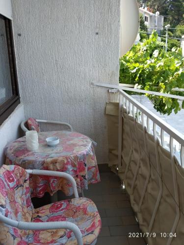 a balcony with a table and chairs and a window at Apartments Raguz in Cavtat