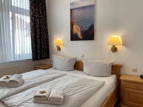 um quarto com 2 camas e toalhas em Haus Jahreszeiten em Binz