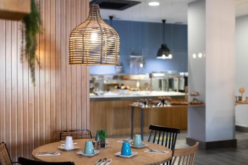 a dining room table with chairs and a light fixture at Petit Palace Ruzafa in Valencia