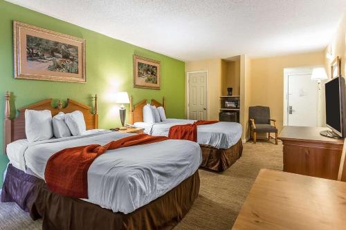 Habitación de hotel con 2 camas y TV de pantalla plana. en South Bay INN en Myrtle Beach