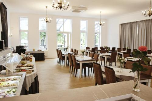 un comedor con mesas, sillas y ventanas en Savoy, en Spała