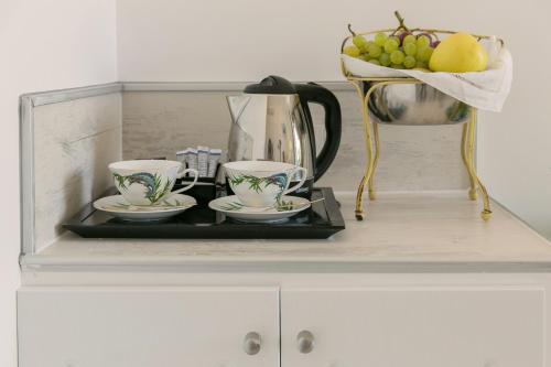 a tray with two cups and a bowl of fruit on a cabinet at Hostal Central Palace Madrid in Madrid