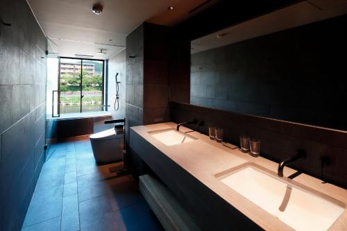 La salle de bains est pourvue de 2 lavabos et d'une fenêtre. dans l'établissement SGR鴨川, à Giommachi