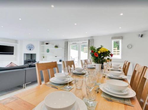 un comedor con una mesa con platos y sillas en Priory House; sleeps 6-20, en Goodleigh