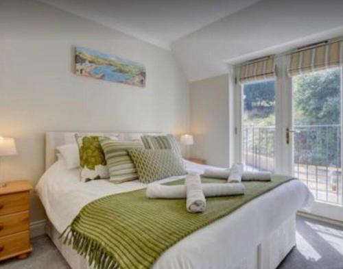 a bedroom with a large bed with a window at Priory House; sleeps 6-20 in Goodleigh