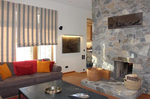 a living room with a couch and a stone fireplace at ClubHotel Hinterthal Am FlorySee 12 in Hinterthal