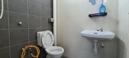 a bathroom with a toilet and a sink at Rest n Splash by Home Stay Cikgu D'Inapan Kijang in Alor Setar