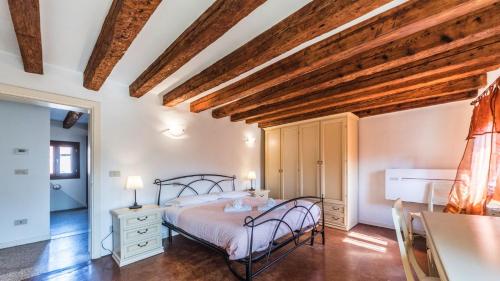 a bedroom with a bed in a room with wooden ceilings at Residenza Al Mercato Grand Canal in Venice