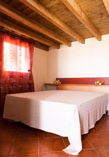 a bedroom with a white bed with a red curtain at Case Vacanze Longo in Balestrate
