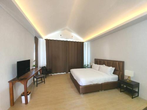 1 dormitorio con 1 cama y escritorio con ordenador en Phorpun Resort 