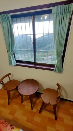 two tables and two chairs in a room with a window at Song Mao Homestay in Leye