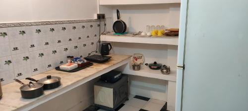 eine Küche mit Töpfen und Pfannen auf einer Theke in der Unterkunft Olive Greens Homestay in Dehradun
