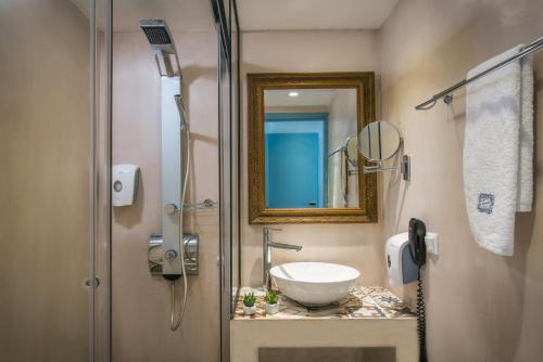 a bathroom with a sink and a mirror at Enorme Serenity Spritz - Adults Only in Hersonissos