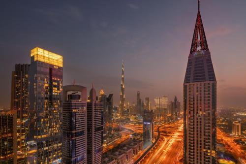 a night view of a city with a tall building at Staybridge Suites Dubai Financial Centre by IHG in Dubai