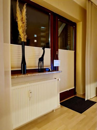 une fenêtre avec une statue de girafe sur un rebord de fenêtre dans l'établissement Moderne Ferienwohnung im Herzen von Schleswig, à Schleswig