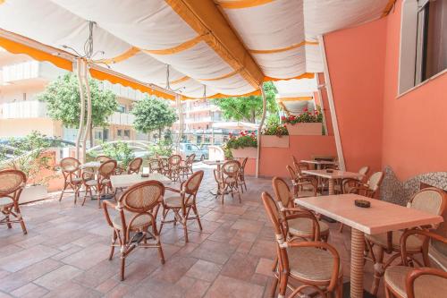 patio restauracji ze stołami i krzesłami w obiekcie Hotel Joli w Cesenatico