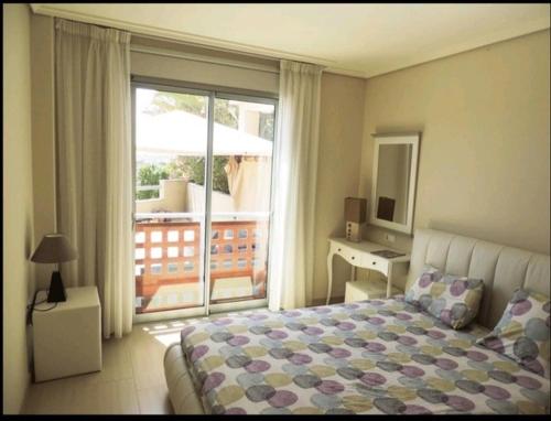 een slaapkamer met een bed en uitzicht op een balkon bij Médano Tejita sunny garden +bbq+parking+pool in Granadilla de Abona