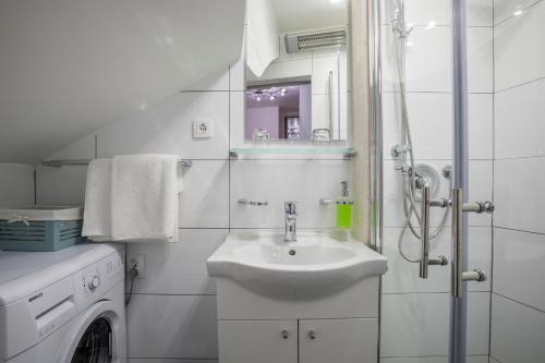 a white bathroom with a sink and a washing machine at ToMaDi Residence in Split
