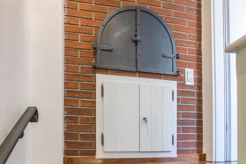 a brick wall with a white cabinet and a metal door at ToMaDi Residence in Split